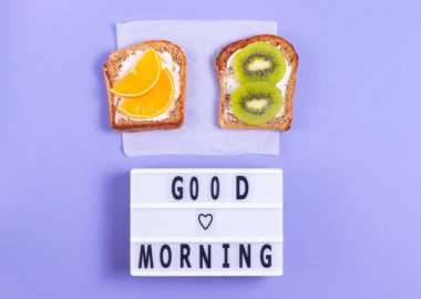 Günaydın, mor arka planda kahvaltıda meyveli sandviçlerle birlikte mektuplar.