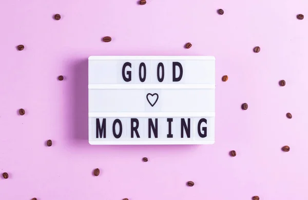Надпись Добрым Утром Белой Доске Розовом Фоне Кофейными Зёрнами — стоковое фото
