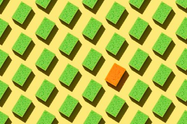 Sarı arka planda bulaşık yıkamak için kusursuz yeşil süngerler.