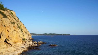 Uzakta küçük yelkenli tekne ile Rocky plaj