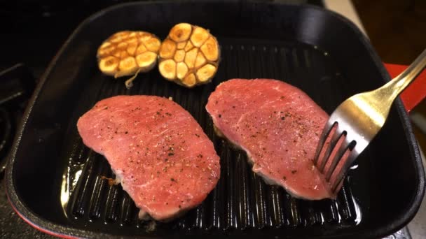 にんにく焼き鉄鍋で肉を回すクローズアップ — ストック動画