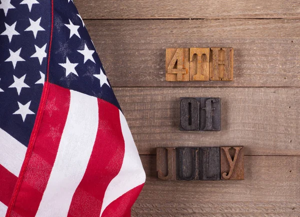 美国国旗与7月4日文本在一个质朴的木质背景 — 图库照片