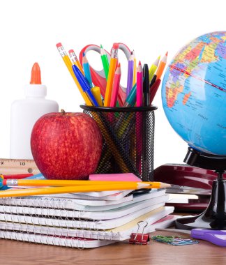Okul malzemeleri ahşap masaüstü ve beyaz arka plan üzerinde ürün yelpazesine