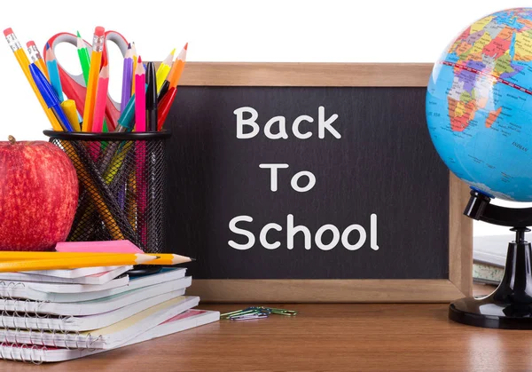 学校付属木製デスクトップおよび白い背景に黒板に書かれた学校 に戻るテキスト — ストック写真
