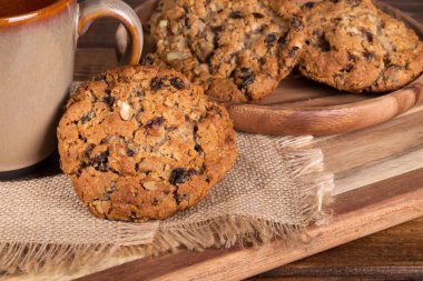 Üzümlü cevizli yulaf ezmesi kurabiye kurabiye arka planda bir kahve fincan bir plaka ile karşı