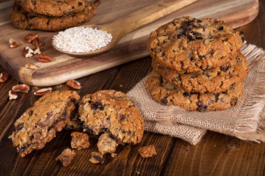 Parçalar ve üzümlü cevizli yulaf ezmeli kurabiye bir rustik ahşap yüzeyde bir yığın