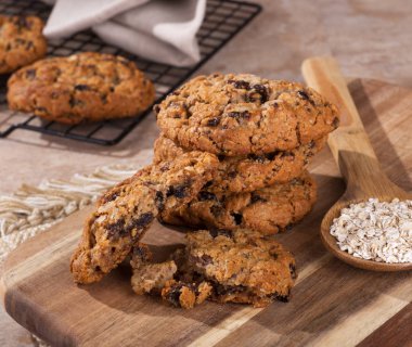 Yulaf ezmesi kuru üzüm kurabiyeleri bir ahşap tahta bir kaşık yulaf ezmesi gevreği ile yığını