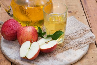 Kırmızı elma ve elma suyu cam ve sürahi bir ahşap tepsi