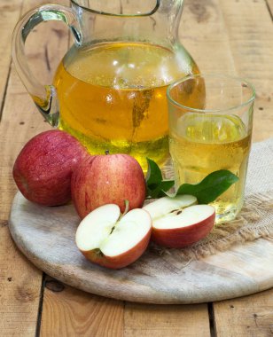 Kırmızı elma ve elma suyu cam ve sürahi bir ahşap tepsi