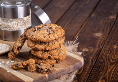 Yulaf ezmesi kuru üzüm fındık kurabiyeleri arka plan ve kopya uzayda malzemelerle ahşap bir gemide yığını