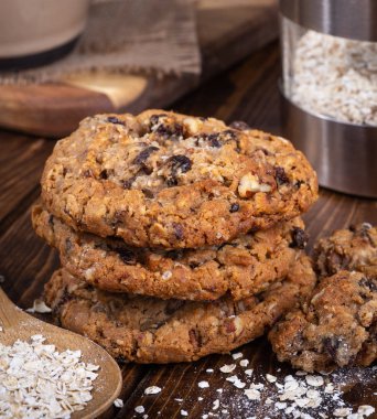 Yulaf ezmesi kuru üzüm fındık kurabiyeleri ve yulaf gevreği bir rustik ahşap yüzeyde yığını