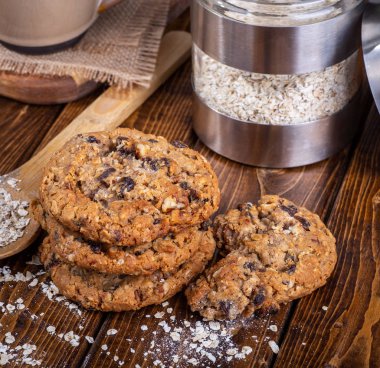 Yulaf ezmesi kuru üzüm fındık kurabiyeleri ve yulaf gevreği bir rustik ahşap yüzeyde yığını