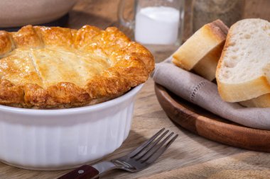 Tavuklu Paçanga böreği beyaz bir kase dilimlenmiş ekmek tarafında ile altın bir kabuk ile closeup