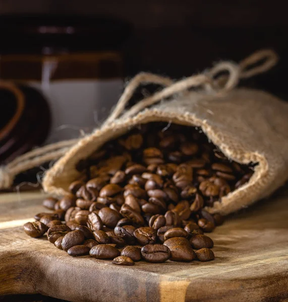 Closeup Coffee Beans Spilled Burlap Bag Wooden Board Dark Rustic — Stock Photo, Image