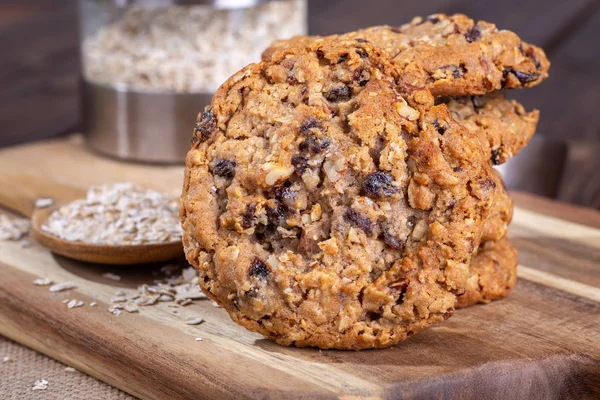 Yulaf ezmesi kuru üzüm fındık kurabiyeleri ile yulaf ezmesi gevreği ahşap tahta üzerinde arka planda bir yığın closeup