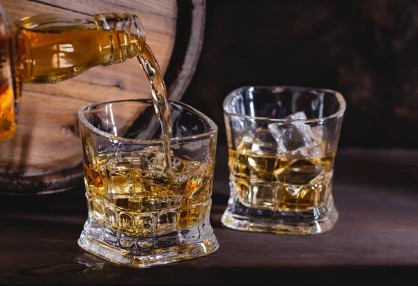 Pouring Whiskey into a Glass With Ice — Stock Photo, Image