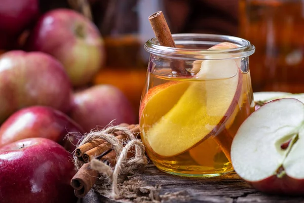 Vaso de jugo de manzana con manzanas en rodajas y palillo de canela — Foto de Stock