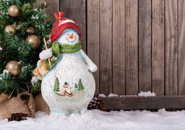 Χιονάνθρωπος δίπλα σε ένα χριστουγεννιάτικο δέντρο — Φωτογραφία Αρχείου
