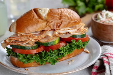 Hindi sandviçi ve salatalık. Tabakta domates ve marul