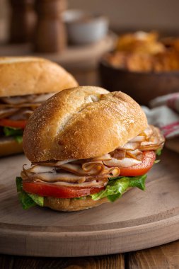 Sağlıklı sandviç, hindi dilimleri, domates ve marul, tahtanın üzerinde.