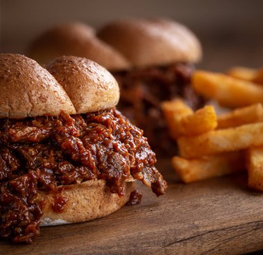 Tahta bir tahtanın üzerinde ızgara biftekli sandviç.