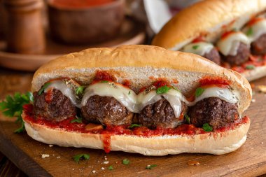 Meatball sandwich with tomato sauce and cheese on a hoagie roll clipart