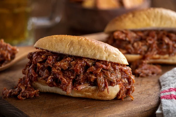 Barbecue pulled pork sandwich on a bun on a rustic wooden board