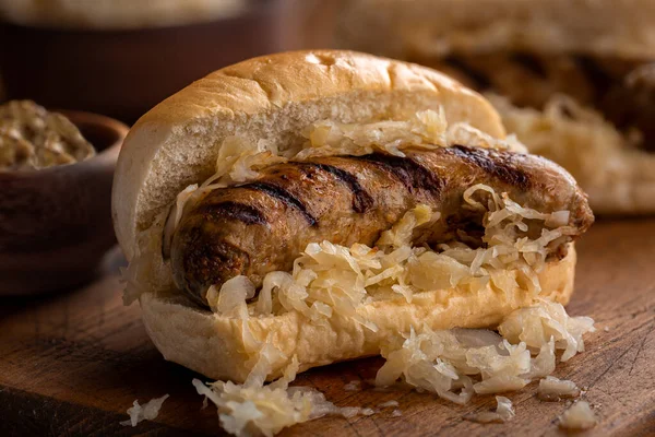 Primo Piano Bratwurst Alla Griglia Con Crauti Panino Una Tavola — Foto Stock