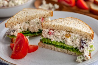 Chickrn salatalı sandviç ve kepekli ekmek tabakta ikiye bölündü.