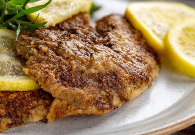 Akşam yemeği tabağında dilimlenmiş limonlu fırınlanmış tilapia balık filetosu.