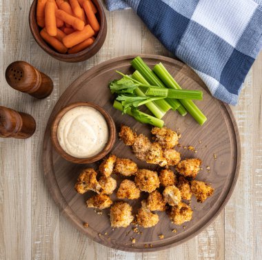 Kızarmış karnabahar çiçekleri ve ahşap tepside havuç ve kereviz ile çiftlik sosu. Genel Görünüm