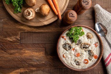 Kırsal ahşap masada bir kase kremalı mantar çorbası. Kopyalama alanı ile genel görünüm