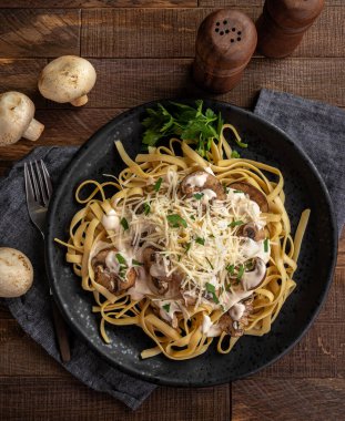 Mantarlı kremalı fettuccine alfredo ve siyah tabakta parmesan peyniri. Genel Görünüm