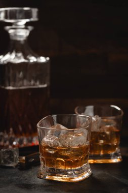 Kopya alanı için iki bardak buzlu viski ve ahşap arka planda sürahi.