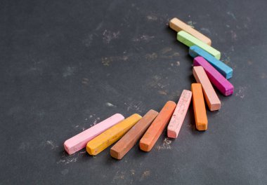 Multicolored chalk on a black background. clipart
