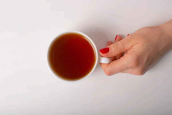 Hand with cup of tea.