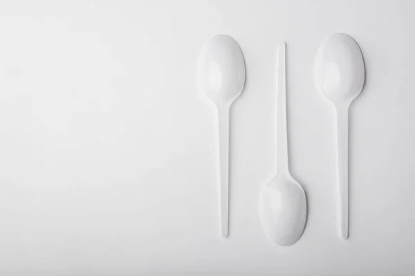 Beyaz arka plan üzerinde üç plastik kaşık.