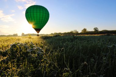 Başkurdistan Cumhuriyeti, Bashkiria - 27.05.2018. Bir el ve kalp balonu teklif edin. Balon kalkışa hazır. Yeşil çimenler, sabah çiy, mavi gökyüzü ve bir balon. Küçük şeylerde mutluluk