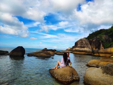 Samui, Tayland - 20.09.2018: Balayı. Aşık yeni evliler Koh Samui sahilinde bir taş üzerinde oturup