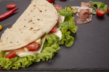 İtalyan piadina romagnola gözleme marul, domates, salam jambon, mozzarella peyniri ve kızarmış kabak ile