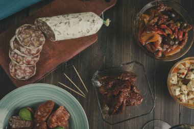 Kase ve kurutulmuş domates ve zeytin ile kesme tahtası üzerinde Chorizo ve salam sosis. Bar yılbaşı için hazır. Vintage etkisi. Ek yük
