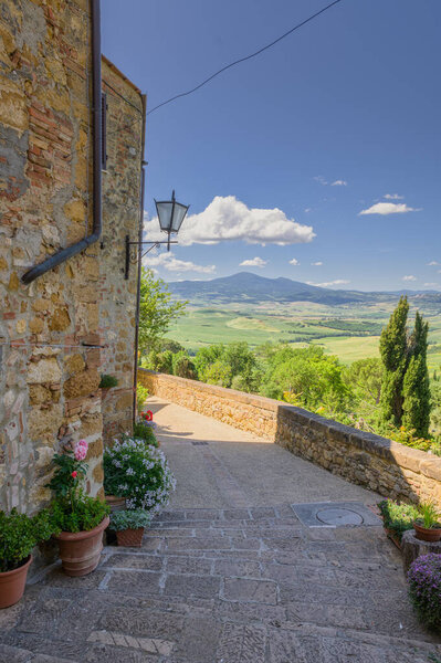 Sunny streets with colorful flowers with contrasting shades. Walk the Tuscan town — Stock Image Sunny Streets Colorful Flowers Contrasting Shades Walk Tuscan Town Stock Photo