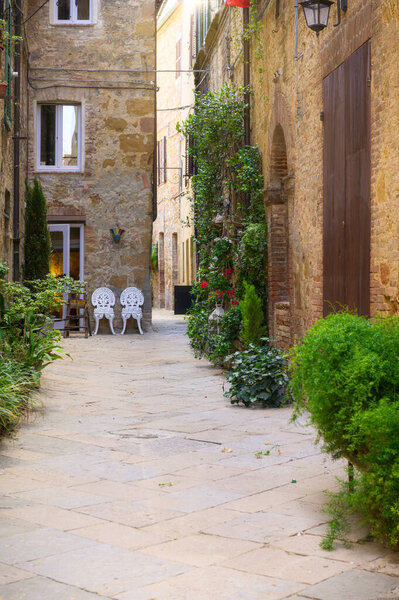 Sunny streets with colorful flowers with contrasting shades. Walk the Tuscan town — Stock Image Sunny Streets Colorful Flowers Contrasting Shades Walk Tuscan Town Stock Photo