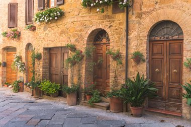Çelişkili gölgeli, renkli çiçekli güneşli sokaklar. Toskana şehrinde yürü