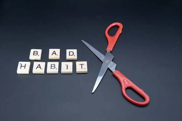 This picture show the scissors and the split word smoking. It represent use the will to quit the bad habit.