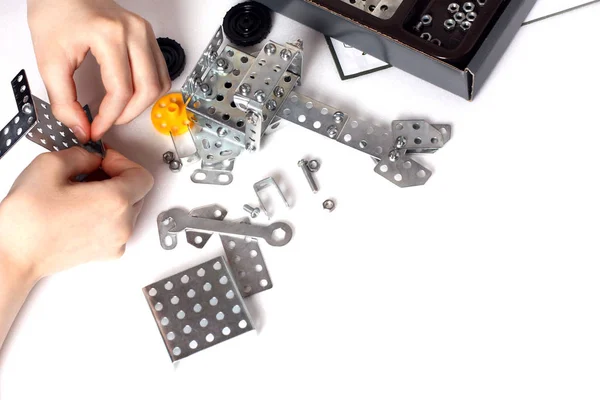 The child collects the metal parts of the child model kit — Stock Photo, Image