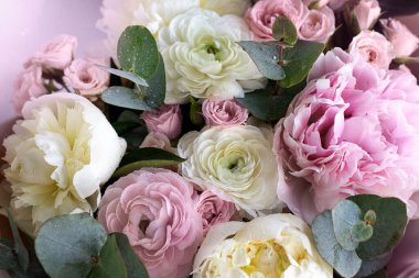 Güzel bir buket karışık çiçek. Çiçekçi konsepti, çiçek teslimatı. Şakayık ve güllerden oluşan bir buket yakın plan..