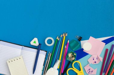 Mavi arka planda okul malzemeleri. Okula dönüyorum. Uzayı kopyala Düz yatıyordu.