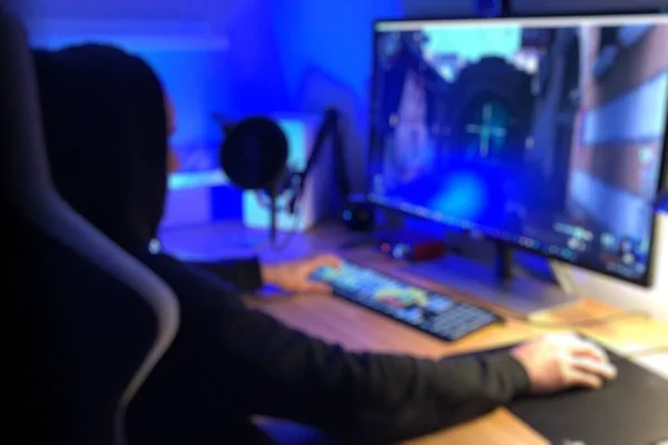 Teenage PC Gamer Playing First-Person Shooter in Subdued Light