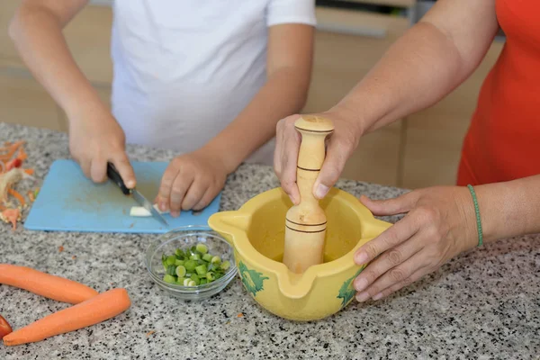 Το παιδί κόβει το σκόρδο προετοιμάζοντας το γεύμα με έναν ενήλικα — Φωτογραφία Αρχείου